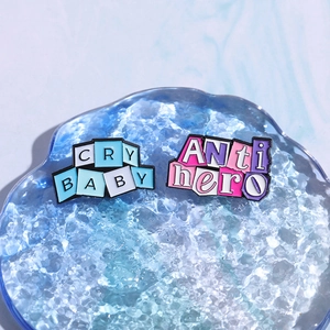 Set aus Emaille-Anstecknadeln in Rosa und Blau mit 'CRY BABY' und 'Anti Hero' Schriftzug