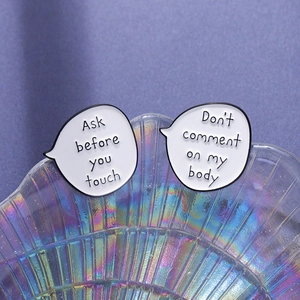Minimalist white speech bubble enamel pins with social slogans in a holographic glass bowl