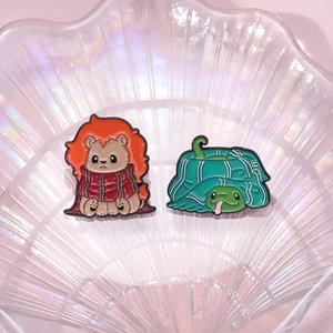 Pins émaillés lion et serpent mignons dans un plateau coquillage sur fond rose