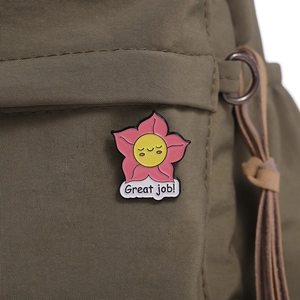 Détail de la broche fleur en émail rose avec texte « Great job! » sur tissu
