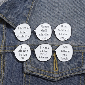 Set of six enamel pins with mental health phrases displayed on a denim jacket