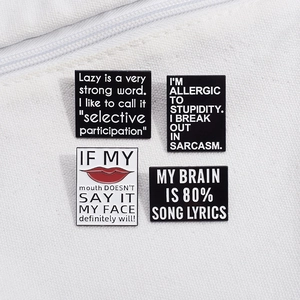 Set of four minimalist enamel pins with inspirational quotes on white canvas background