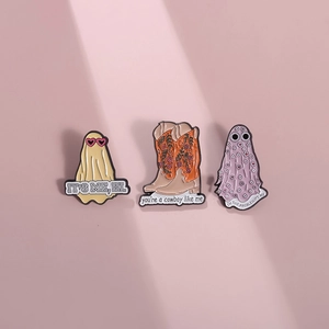 Three-piece enamel pin set with cowboy boots and ghost designs on soft pink background