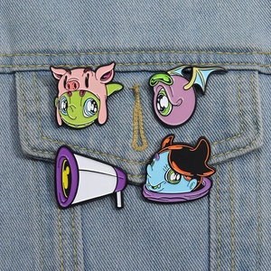 Creative cartoon enamel pin set featuring cute monsters on a denim jacket pocket