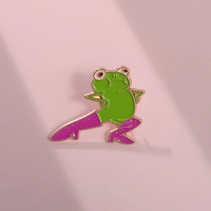 Funny green frog enamel pin wearing pink glitter boots with rose gold metal edges