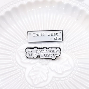 Set of two geometric speech bubble pins with witty motivational quotes in black and white