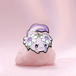 Cute lavender axolotl enamel pin with daisy flowers on pink crystal stone