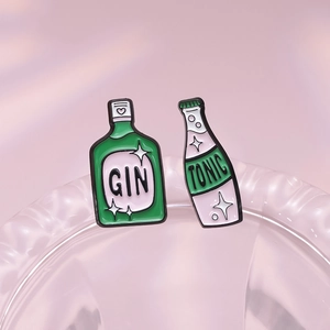 Set di spille in smalto a forma di bottiglie di gin e tonic su sfondo rosa