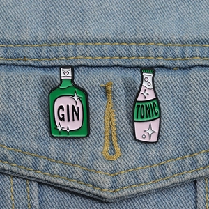 Set di spille in smalto a forma di bottiglia di Gin verde e Tonic rosa su denim