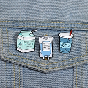 Détail de badges en émail Student Tears sur veste en jean bleue pour un style créatif