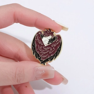 Detailed enamel pin featuring two anime characters with red wings held by hand