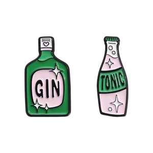 Set di spille in smalto gin e tonic con dettagli a cuore e stelle su sfondo bianco