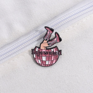 Détail de la broche en émail rose avec boule disco, bottes et texte Bejeweled