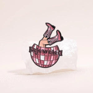 Gros plan d'un pin's émaillé boule à facettes rose Bejeweled sur des cristaux