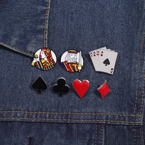 Detail of 7-piece poker themed enamel pins featuring card suits and royalty on denim jacket