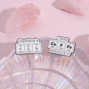 Cartoon chemical element enamel pins featuring Chemistry is FUN on pink decor