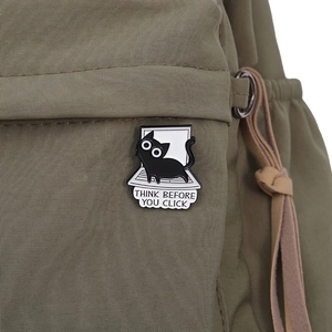 Détail du pin's chat noir avec texte Think Before You Click sur un sac en nylon