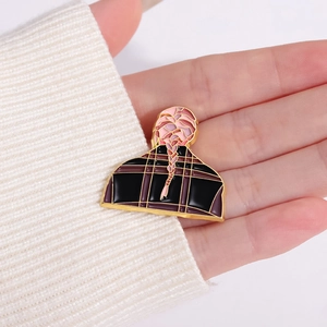 Broche en alliage fille chanteuse aux nattes roses tenue dans la main nue