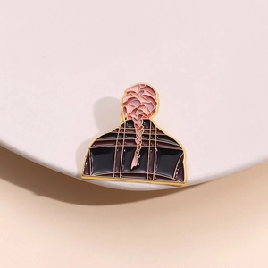 Vue détaillée du pin's en émail montrant une coiffure tressée et une tenue à carreaux
