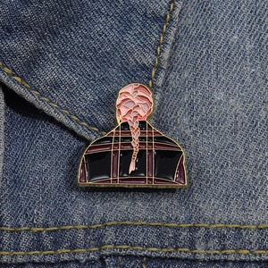 Broche créative en émail avec motif tresses roses sur le col d'une veste en denim