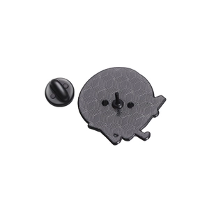 Detailed back view of a round black enamel pin showing non-slip honeycomb texture and clasp