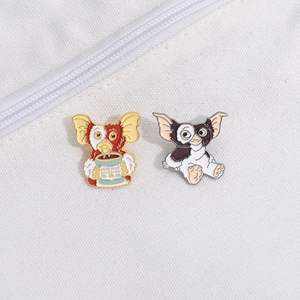 Close-up of Gizmo enamel pins featuring cute Gremlins movie characters on canvas bag