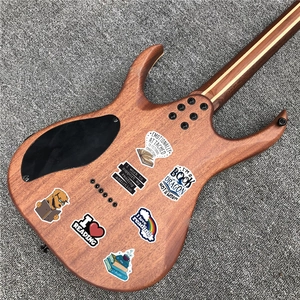 Close-up of waterproof reading-themed stickers on a matte wood-finish electric guitar