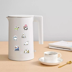 Detailed view of cute duck stickers on a white kettle in a lifestyle home setting
