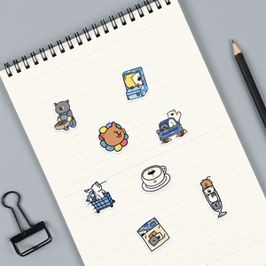 Close-up of cute cartoon animal stickers on a notebook with clips and pencils