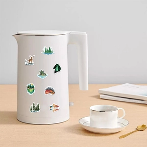 Nature stickers with forest and animal motifs applied on a white electric kettle for decor