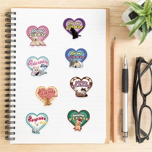 Detail of vintage heart-shaped pet stickers with cat and dog doodles on a white notebook