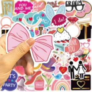 Gros plan d'une main tenant un autocollant nœud rose d'un kit de 52 stickers de mariage