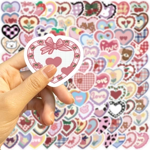 Macro detail of heart-shaped doodle stickers with cute patterns held by a hand
