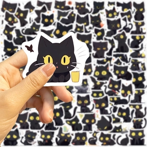 Close-up of waterproof cartoon black cat stickers with yellow eyes for laptops