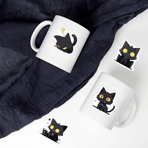 Waterproof cartoon black cat stickers decorating a white ceramic mug in a creative setup