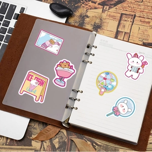 Close-up of colorful cartoon stickers decorating a brown leather notebook diary