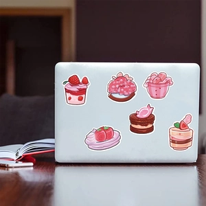 Adesivi per dolci rosa su un laptop in un ambiente accogliente di ufficio in casa