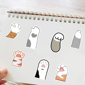 Close-up of cute cartoon cat paw stickers decorated on a white coil notebook page