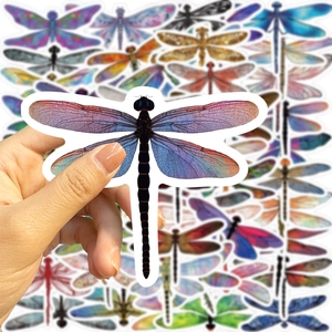 Detailed view of hand holding watercolor dragonfly stickers for scale and pattern detail