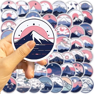 Close-up of hand holding a waterproof Fuji mountain sticker for laptop and guitar decoration