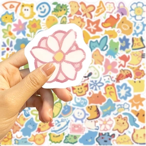 Hand holding pink flower sticker from a 100pcs colorful cartoon DIY waterproof set