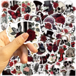 Close-up of hand holding a gothic punk rose and butterfly sticker with a pile background