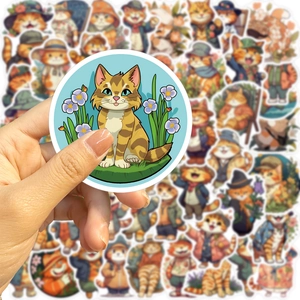 Close-up of cute cartoon orange cat stickers being held for DIY laptop decoration