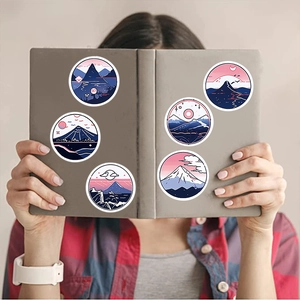 Close-up of Japanese style mountain stickers applied on a gray notebook cover