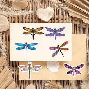 Artistic dragonfly stickers on vintage envelope with dried flowers and bamboo mat decor