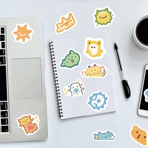 Flat lay of colorful cartoon animal stickers on a laptop and notebook for DIY decoration