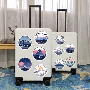 Waterproof round mountain stickers applied on white suitcases in a cozy room