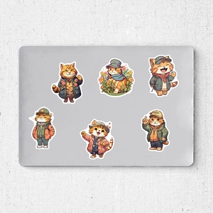Detail of cute ginger cat stickers in outdoor outfits applied on a silver laptop lid