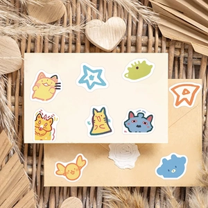 Close-up of nine cute cartoon animal stickers on a warm beige background for DIY decor
