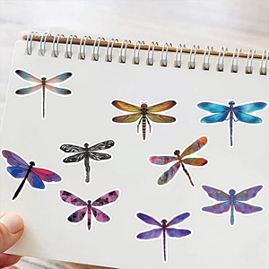 Detail shot of assorted colorful waterproof dragonfly stickers on a spiral notebook